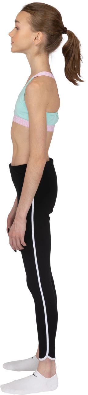 Side view of a teen girl in sportswear standing still and looking aside