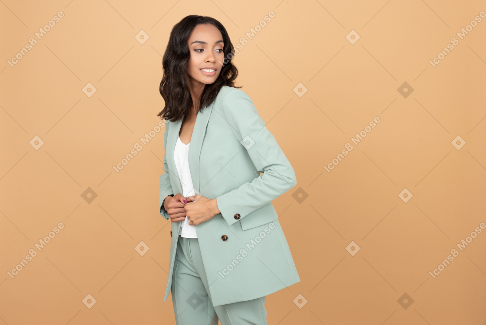 Attractive young woman holding her hands on her jacket an looking aside