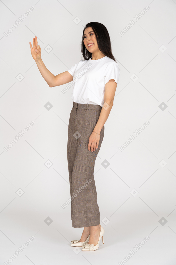 Three-quarter view of a smiling young woman in breeches showing ok sign
