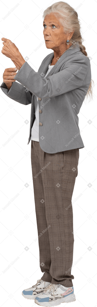 Vista laterale di una vecchia signora in giacca che mostra il pugno