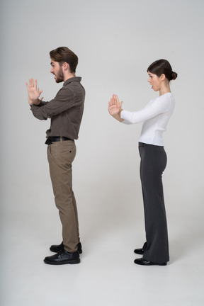 Side view of a young couple in office clothing crossing arms