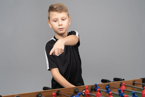 Three-quarter view of a boy playing foosball