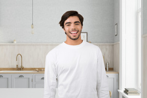 A man standing in a kitchen next to a sink