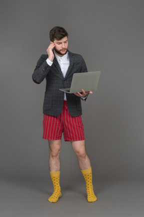 Empresario en shorts rojos trabajando de forma remota