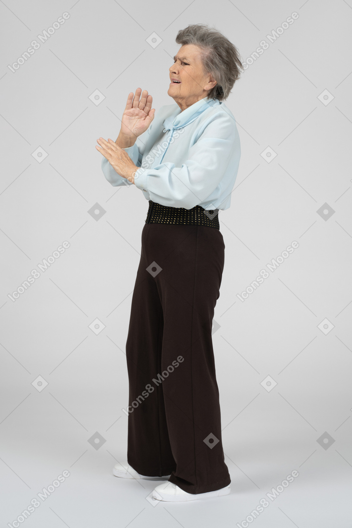 Old woman waving her hands away
