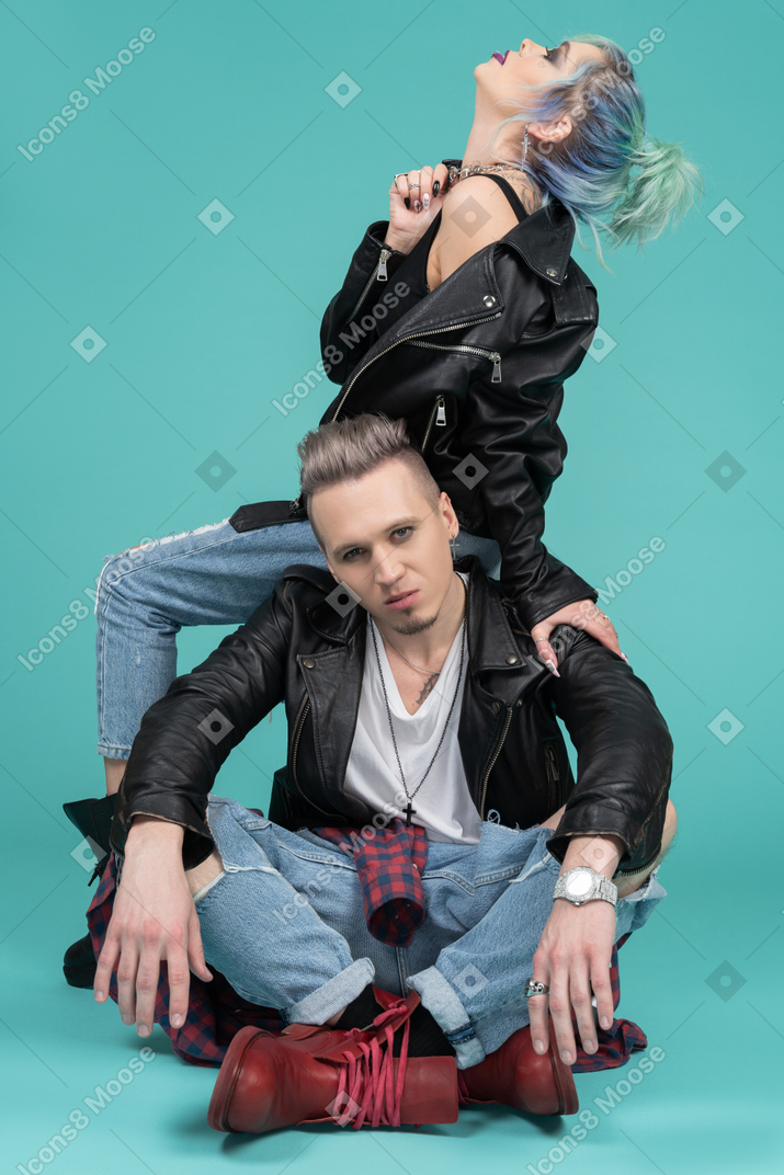 Young punk woman sitting on her boyfriend`s shoulders