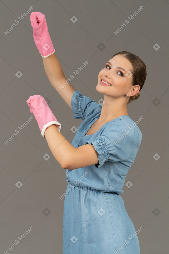 Cheerful young woman wearing cleaning gloves