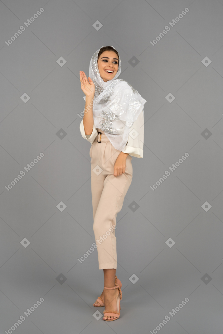 Smiling middle eastern woman laughing and waving hello