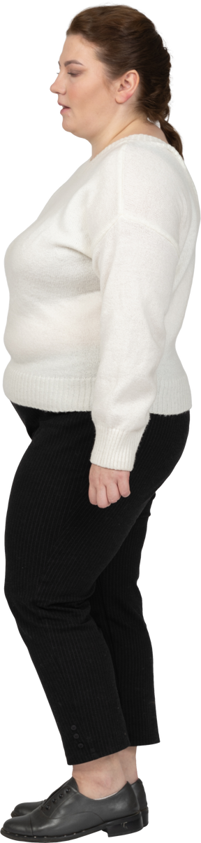 Mujer de talla grande confiada en suéter blanco de pie en el perfil