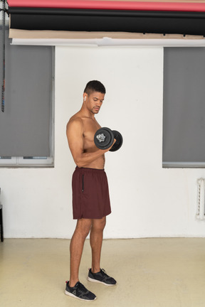 Young man exercising with dumbbell