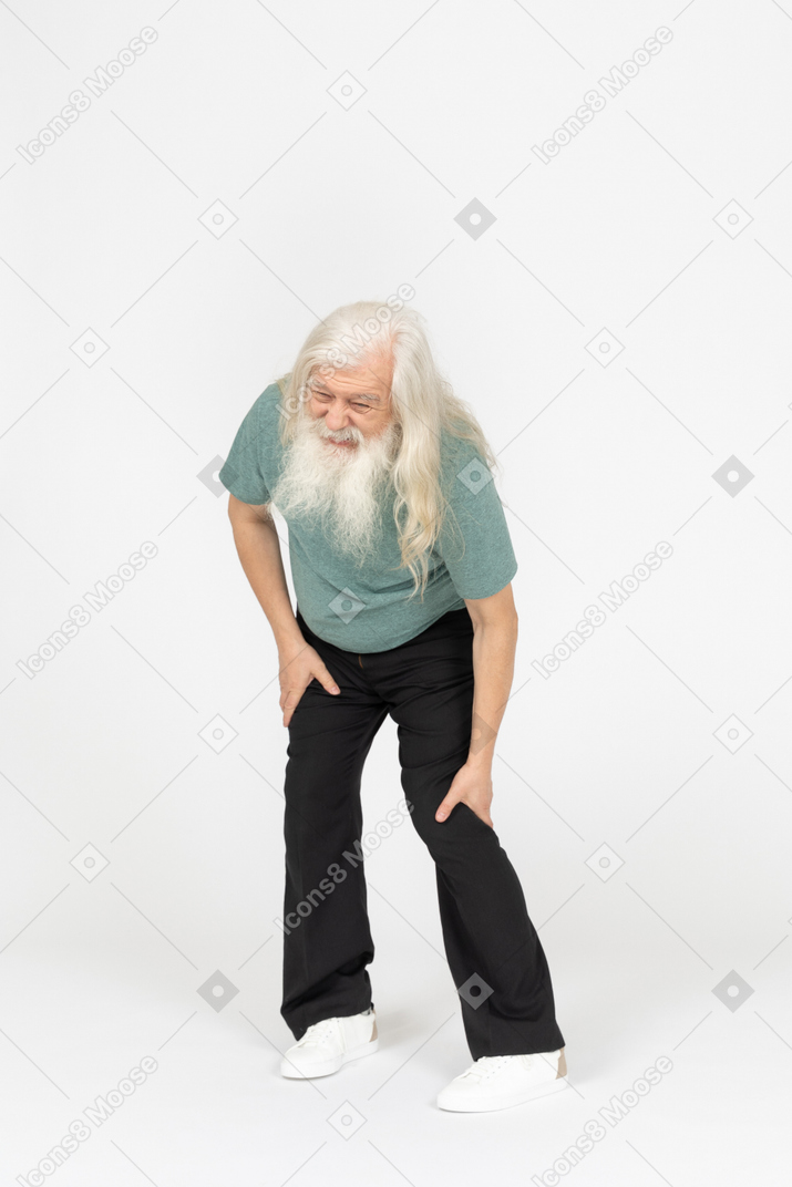 Vista de tres cuartos del anciano que siente dolor en la rodilla