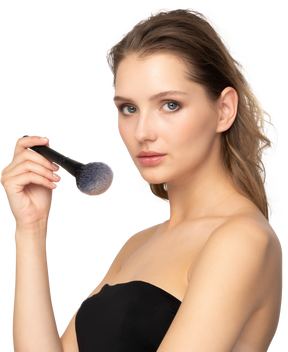 Three-quarter view of a sensual young woman holding a make-up brush