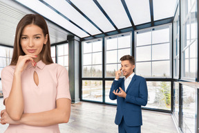 Woman in pink dress standing in front of man in blue suit