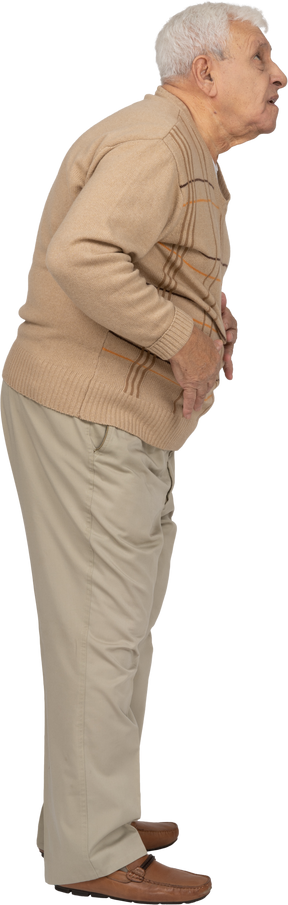 Vista lateral de un anciano impresionado con ropa informal mirando hacia arriba