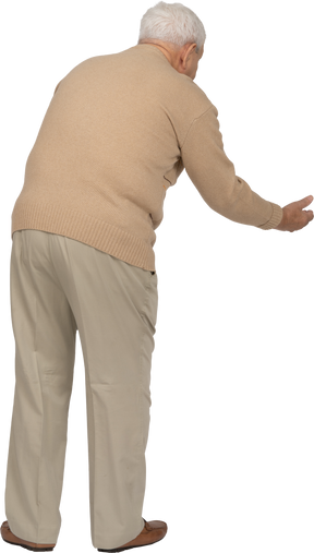 Vista posteriore di un vecchio in abiti casual che si china con il braccio teso