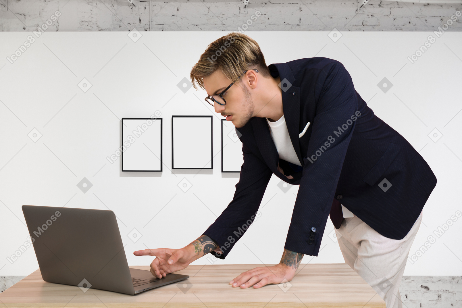 A man in a suit leaning over a laptop