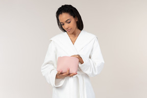 Black woman in white bathrobe going about her morning routine