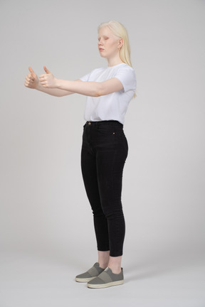 Three-quarter view of a young girl showing two thumbs up