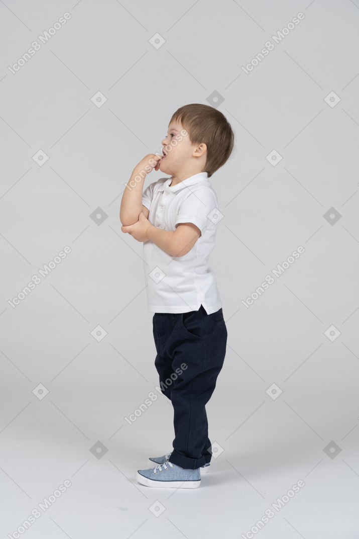 Side view of small boy standing and gesturing