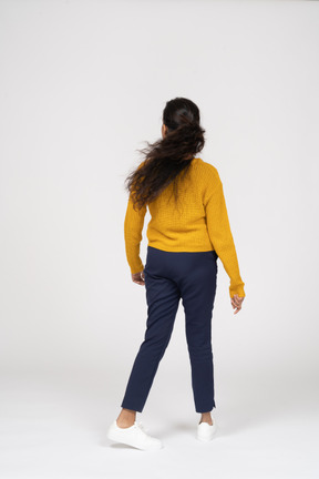 Rear view of a girl in casual clothes walking