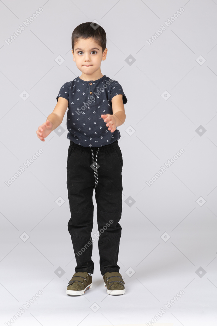 Vista frontal de un chico lindo en ropa casual aplaudiendo
