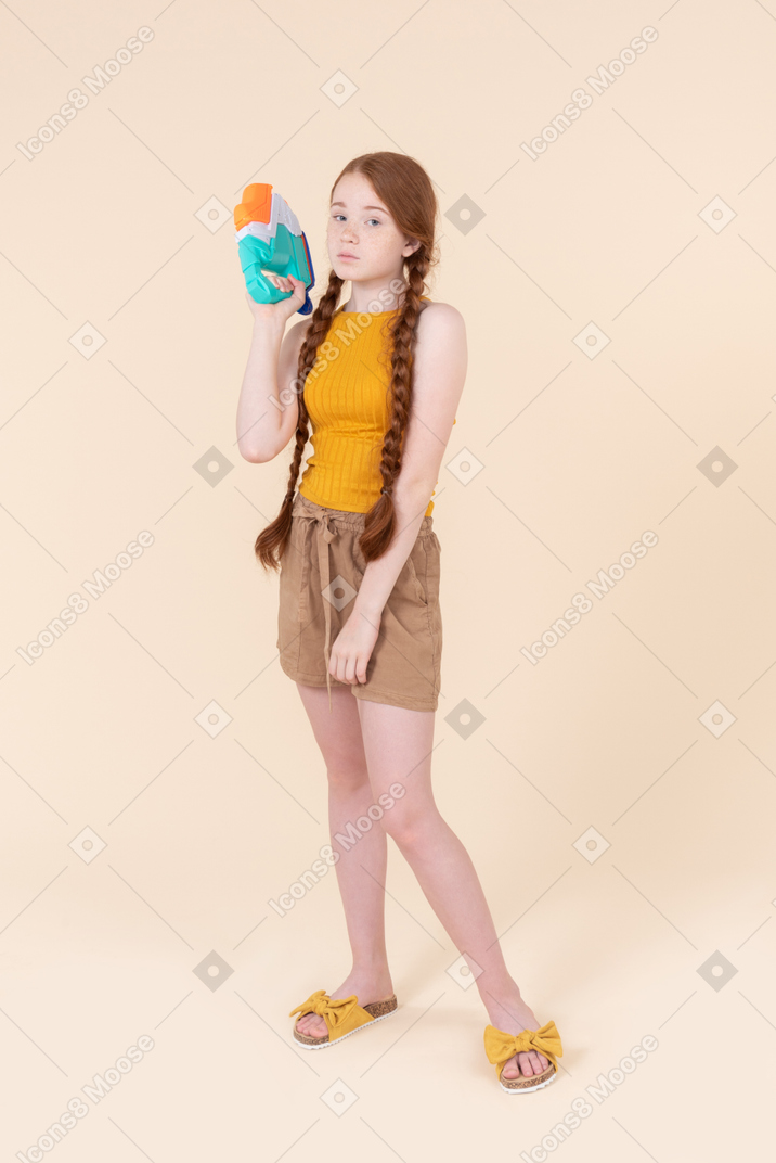 Teenage girl holding water gun