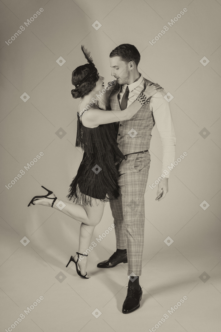 Well-dressed woman and man holding each other tight