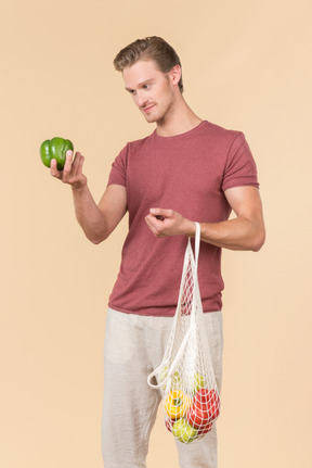 Young guy holding a string bag with groceries