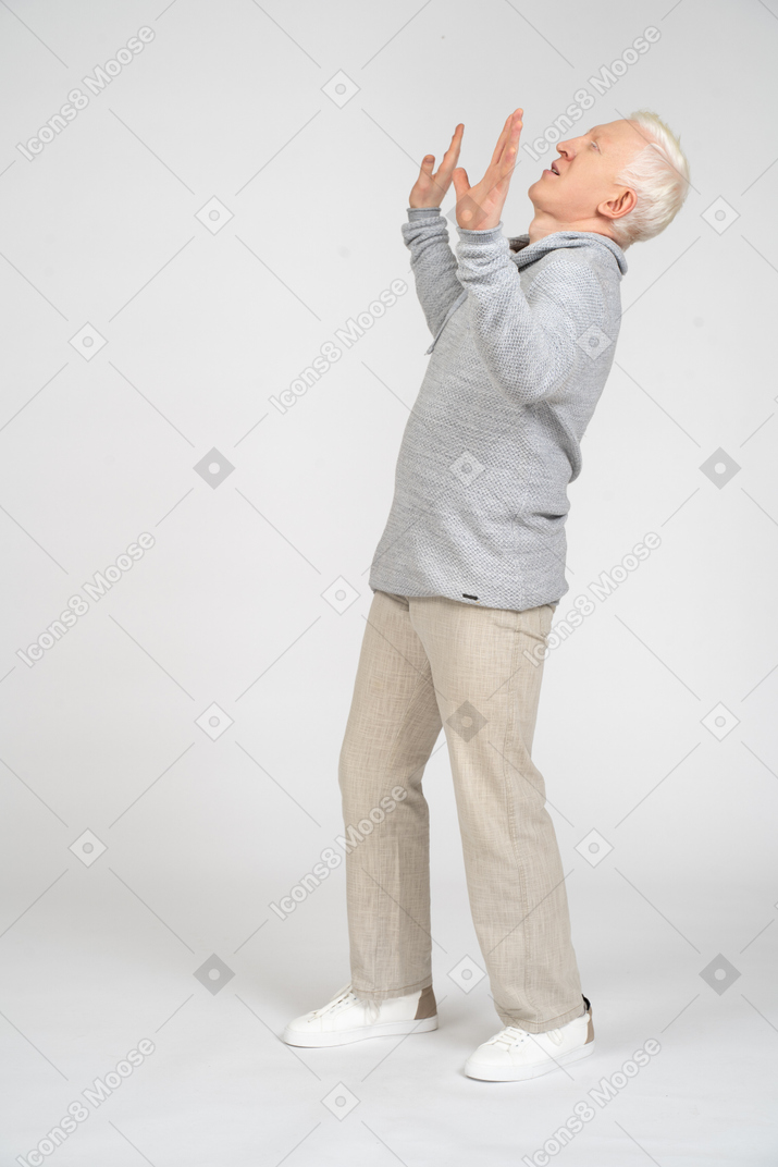 Man with eyes closed and hands up bending backward