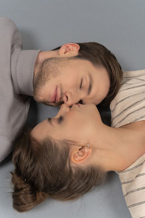 Close-up of a couple lying down with eyes closed