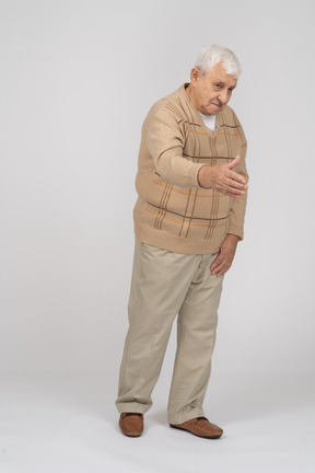 Vue de face d'un vieil homme en vêtements décontractés donnant un coup de main pour secouer