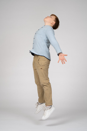 Side view of a boy jumping and looking up