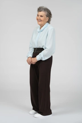 Three-quarter view of an old woman smiling with clasped hands