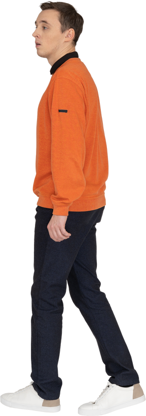 Giovane uomo in felpa arancione a piedi