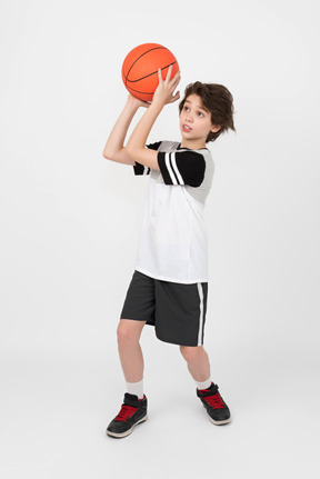 El chico está listo para lanzar una pelota de baloncesto.