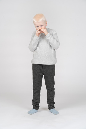 Front view of a boy covering his mouth with hands
