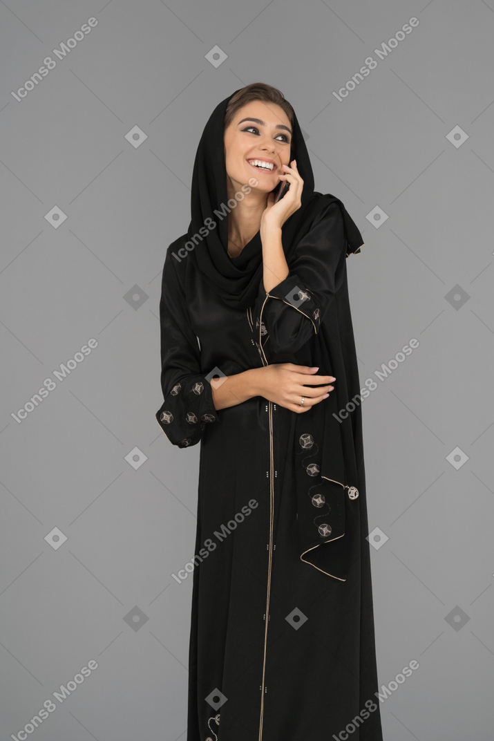 Cheerful muslim woman talking on a phone
