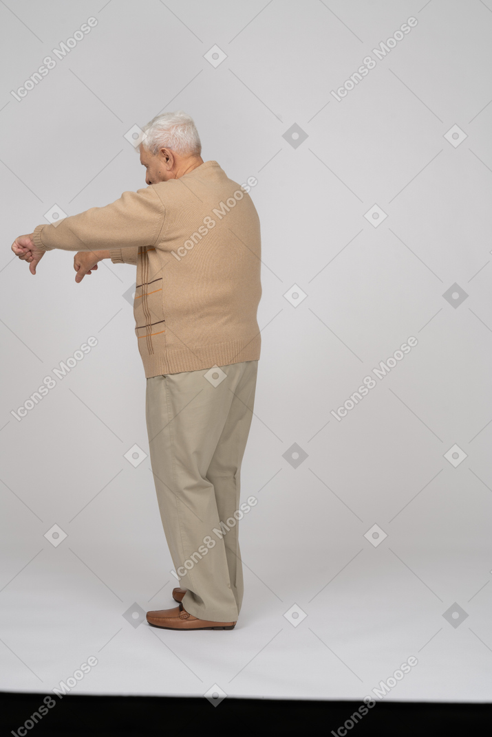 一位穿着休闲服的老人的后视图，拇指朝下