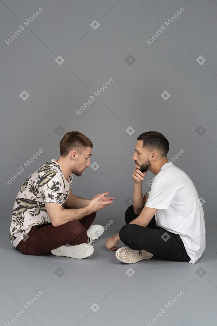 会話している2人の関係する若い男性の側面図