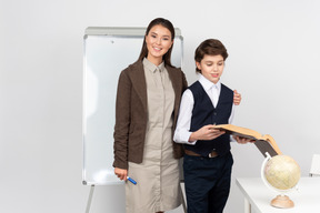 Heureux jeune enseignant et un écolier debout ensemble