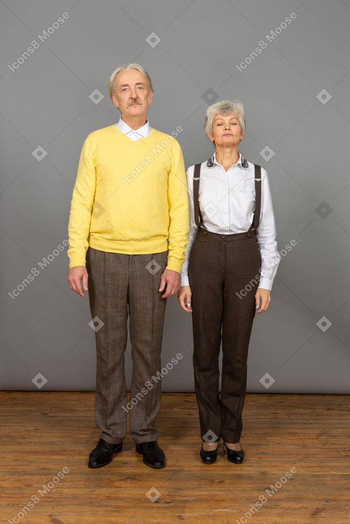 Man and woman standing with arms at sides