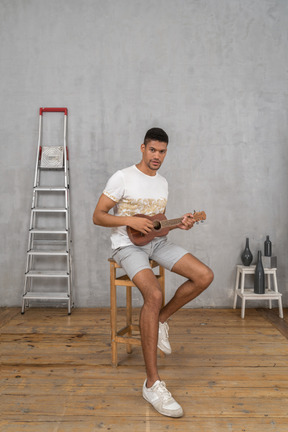 Three-quarter view of a man posing with ukulele