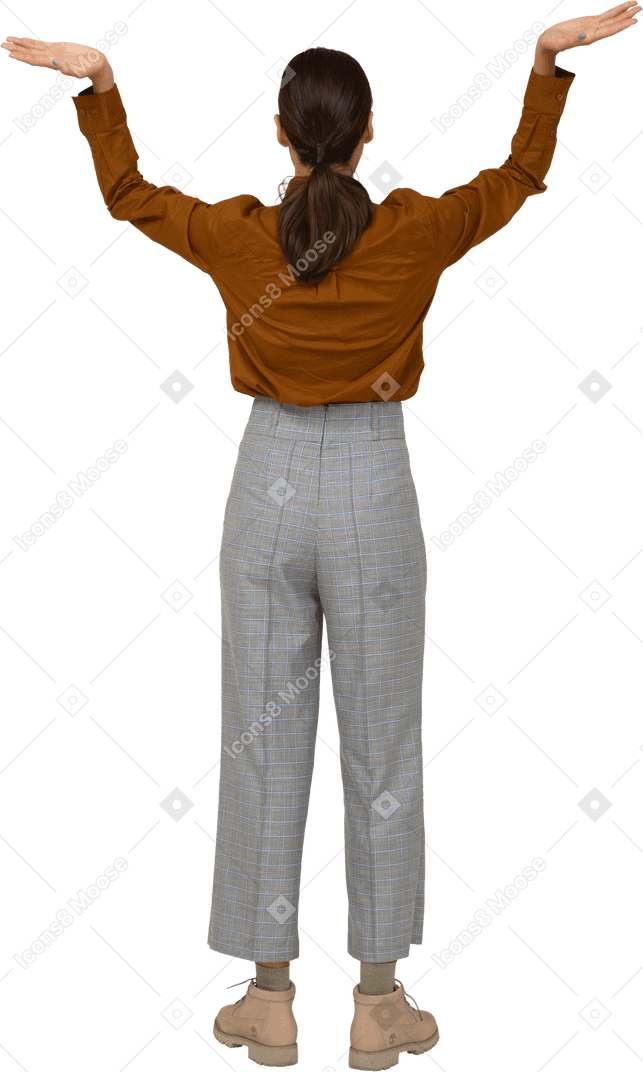 Vista traseira de uma jovem mulher asiática de calça e blusa, levantando as mãos