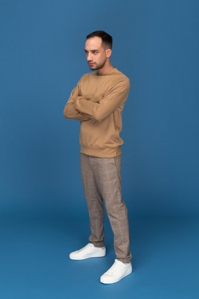 Young man standing with hands crossed