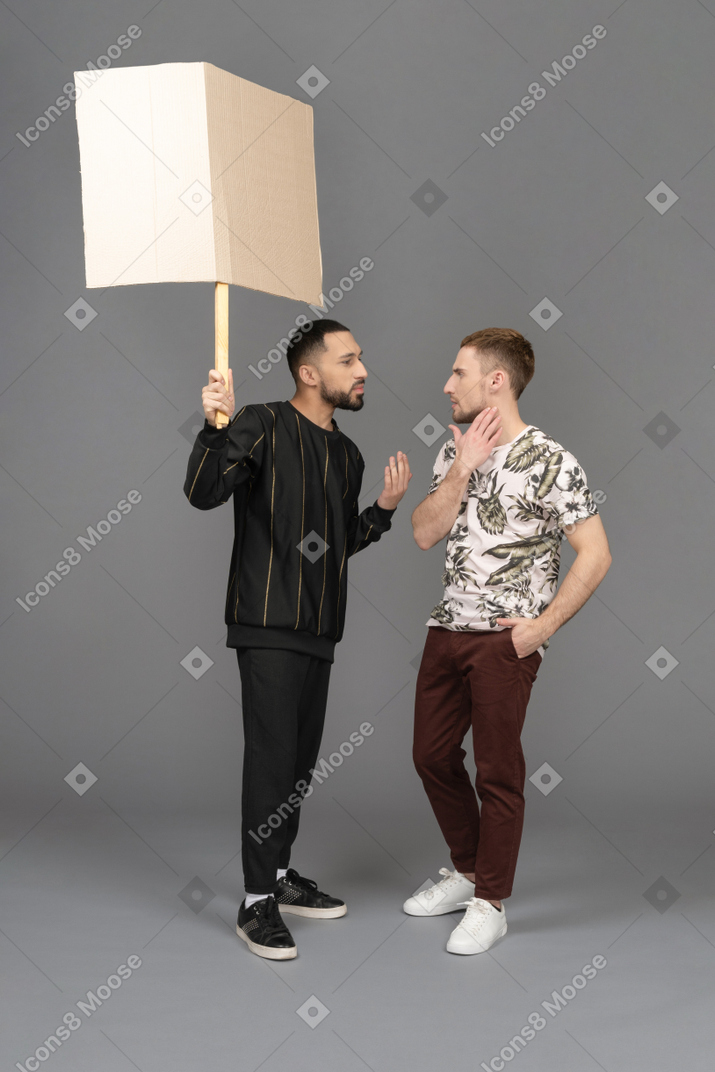 Young man with a billboard explaining something to another young man