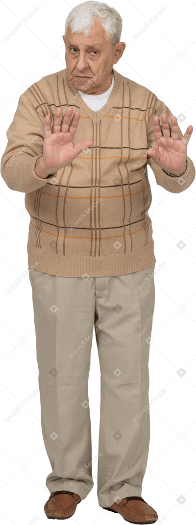 Front view of an old man in casual clothes showing stop gesture