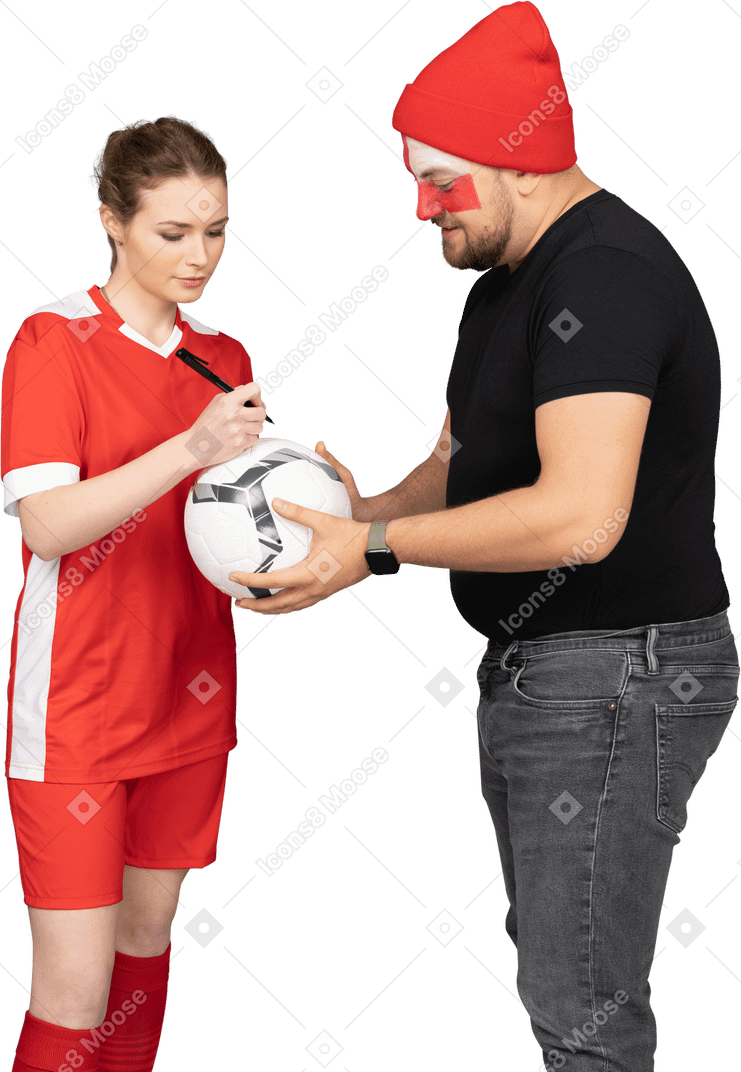Futbolista femenina firmando un balón para el fan