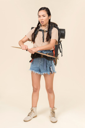 Troubled looking young female hitchhiker holding paper card