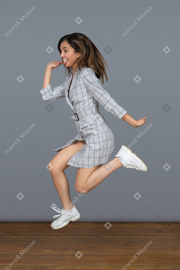 Happy young woman having the best day ever and jumping high