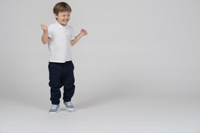 Vista frontal de un niño saltando y sonriendo alegremente